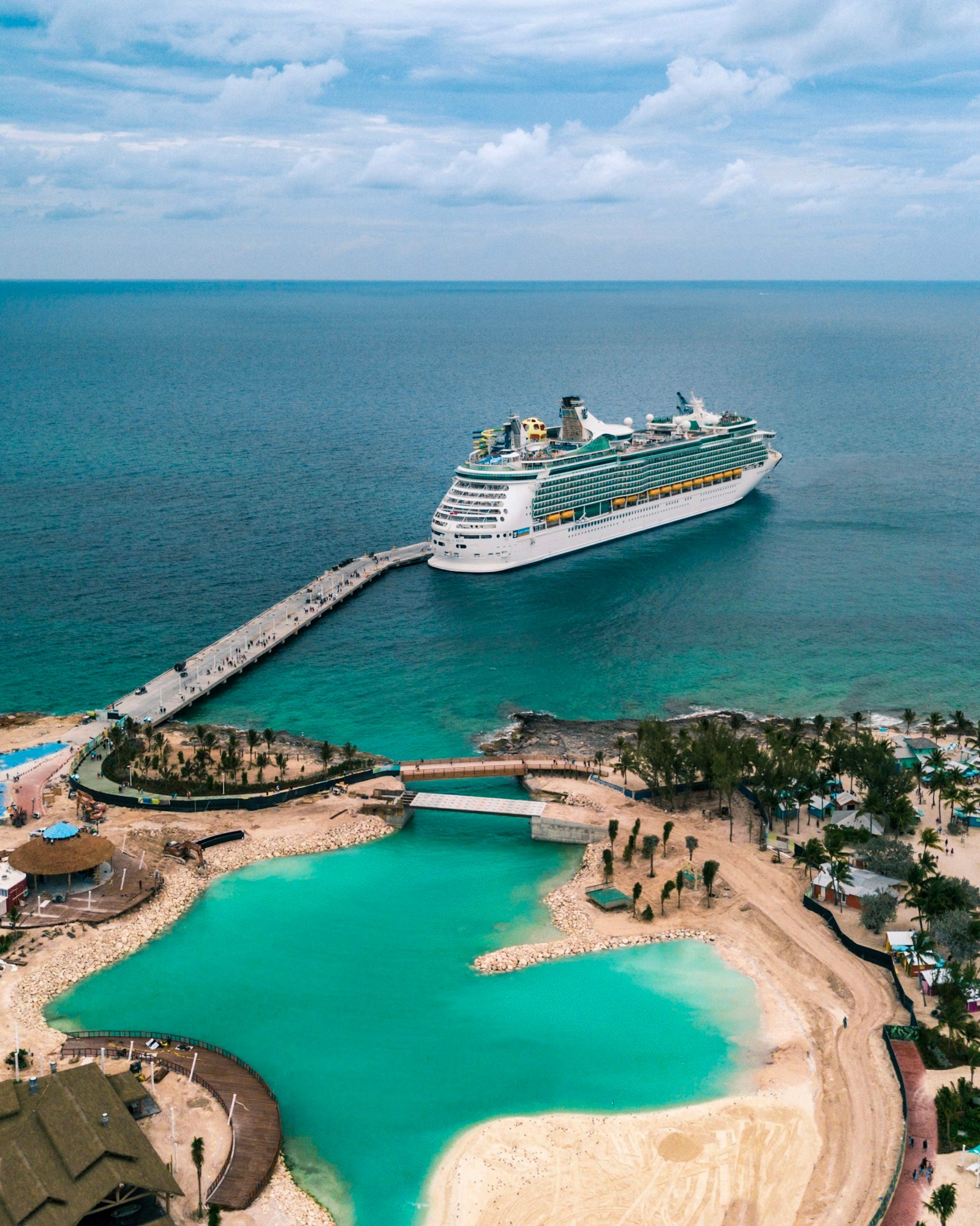 Cruise ship docked beside turquoise water.